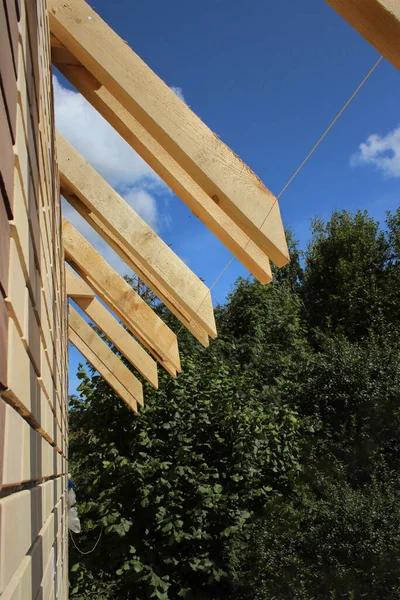 Takrännor som inte är täckta med keramiska plattor på ett fristående hus, synliga takelement, plattor, bänkplattor, takrännor. Industriellt taksystem med trävirke, bjälkar och bältros — Stockfoto