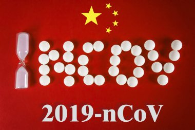 Kum Saati ve Yazıtlar ncov beyaz tabletlerden yapılmıştır. Çin bayrağının kırmızı zemininde 2019 ncov yazısıyla, üst görünüm. 2019 Roman Coronavirus 2019-ncov konsepti