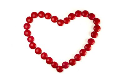 Colorful dragee beans in the shape of a heart on a white background. Decoration background. Closeup