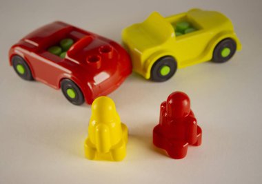 Two desperate men in toy cars involved in accident, conceptual image with miniatures and figurines on white background. Close-up of a collision of two toy cars on a white background.