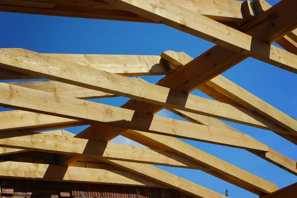 Roof trusses not covered with ceramic tile on detached house under construction, visible roof elements, battens, counter battens, rafters. Industrial roof system wooden timber, beams and shingles