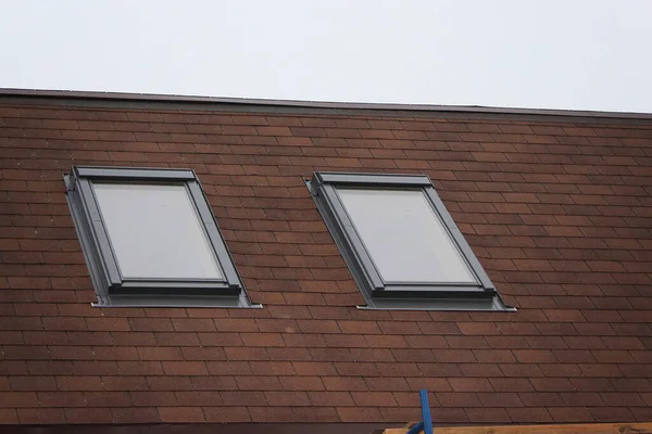 Çatı inşaatı ve çatı pencereli yeni bir ev, bacalı yeni bir tuğla ev. Modern çatı penceresi. Tavan arası Ev Tasarımı. Çatı İnşaatı. Çamur Çatı Döşemeleri.