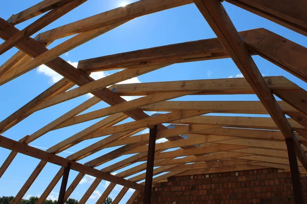 Roof trusses not covered with ceramic tile on a detached house under construction, visible roof elements, battens, counter battens, rafters. Industrial roof system wooden timber, beams and shingles.