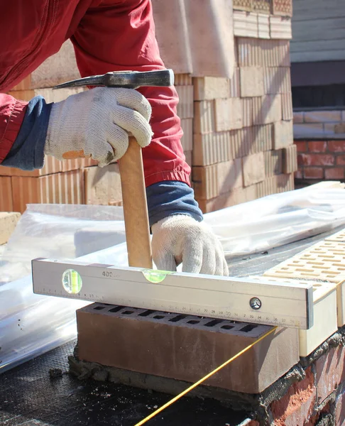 Bricklayers hands with in masonry trowel bricklaying new house wall on foundation. Close up of industrial bricklayer installing bricks. Bricklayer and mason working with bricks and building walls — Stock Photo, Image