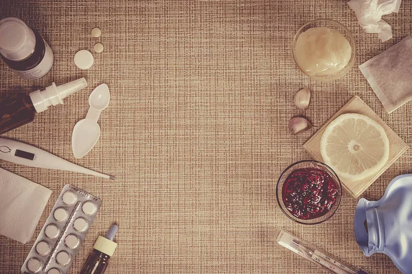 Traditional And Modern Cold Medicine. Treatment of colds and flu. Sick day and flu concept. Various medicines, a thermometer, sprays from a stuffy nose on brown background. Copy space.