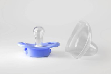 Beyaz arka planda mavi bebeğin emziği. Boşluğu kopyala.