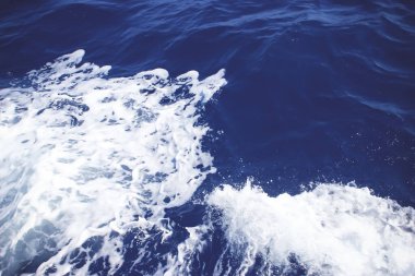Arka planda deniz köpüğü olan Mavi Deniz Suyu. Spreyli derin mavi deniz suyu. Okyanus suyu arkaplanı