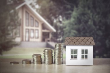 Bozuk paralı ev modeli, masa başı başarısı, bulanık arka plan, özel ev. Tasarruf kavramı, mali. Gelecek için para ve gelir tasarrufu yatırım fikirleri ve mali yönetim. Kapatın. İş büyümesi konsepti. Finansal r