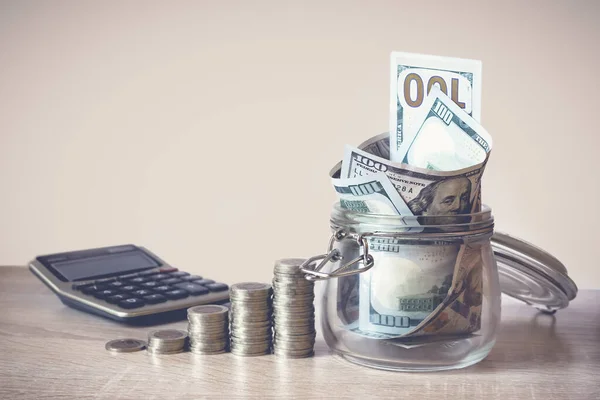 Bozuk paralar, hesap makinesi ve kavanozdaki Amerikan dolarları. Tasarruf kavramı, mali. Gelecek için para ve gelir tasarrufu yatırım fikirleri ve mali yönetim. Kapatın. İş büyümesi konsepti. Mali risk