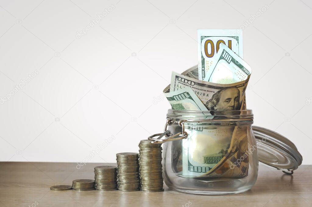 Coins Stack and US dollar bills in the glass jar. Concept of money saving, financial. Savings money and income Investment ideas and financial management for the future. Close up. Business Growth concept. Financial risk
