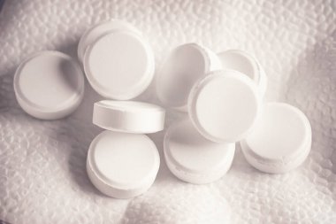 Beyaz arka planda beyaz ilaç hapları var. Tıbbi ve ilaç konularında arka plan görüntüsü. İlaç, eczane ve sağlık hizmetleri. Acısız bir hayat