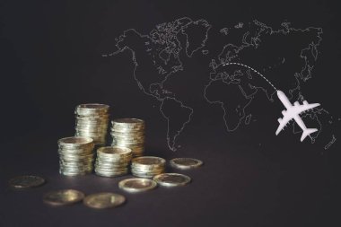 Bozuk paralar, hesap makinesi, sanal hologram dünya haritası ve uçak. Para biriktirme, para biriktirme, seyahat. Tasarruf, gelir yatırımları, yönetim. Dijital pazarlama