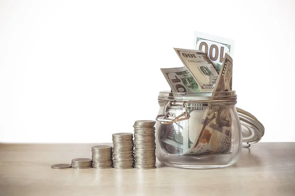 Finans, yatırım ve emeklilik planı. Değişik yükseklikteki para yığınları ekonomik büyümeyi simgeler, banknotlarla dolu cam bankalar, belirli bir amaç için kaydedilen bir sembol