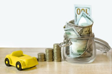 Değişik yüksekliklerdeki madeni paralar ekonomik büyümeyi simgeliyor, banknotlu cam banka, araba için tasarruf simgesi. Para tasarrufu kavramı. Mali sürdürülebilir kalkınma