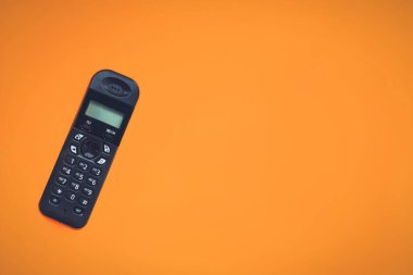 Kablosuz telefon, telsiz telefon, turuncu arkaplandaki kablosuz telefon. Boşluğu kopyala