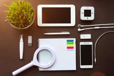 Merkez ofis. Laptop, defter, ofis malzemeleri ve koyu kahverengi arka planlı kırtasiye malzemeleri olan bir ofis. Çözüm, iş planlaması, yaratıcı, tasarım, öğrenme, düz görünüm kavramını başlat veya çalıştır