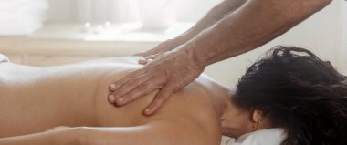 Woman lying on towel receiving a professional therapeutic massage, close-up