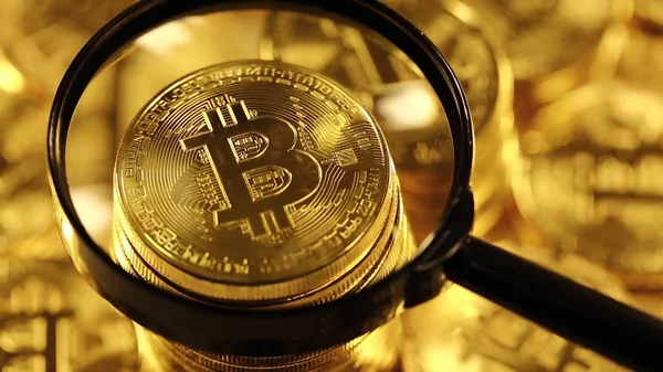 Büyüteç altında altın Bitcoin Sikkeler