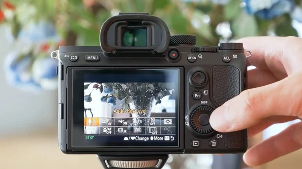 Dijital kamerasındaki ayarları kontrol eden bir adam. Çekim sırasında.