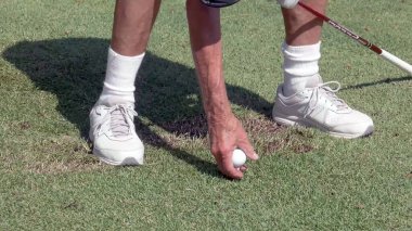 Golfçü eli ve golf topları topa vuruyor.