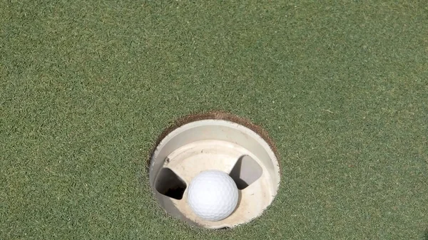 球洞里的高尔夫球 — 图库照片