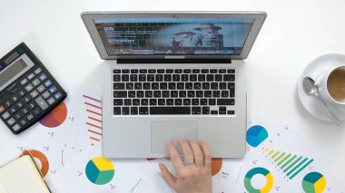 En üst düzey çalışma alanı, dizüstü bilgisayar üzerinde çalışan kadın eli, kahve fincanı, defter, beyaz tahta masa..