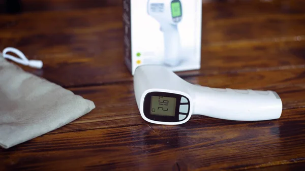 Ahşap masada kızılötesi termometre