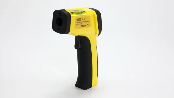 Yellow Infrared thermometer gun on white background