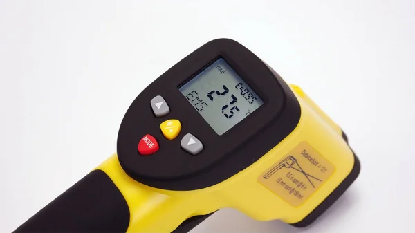 Yellow Infrared thermometer gun on white background