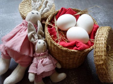 Renkli arka planda saman sepetinde üç yumurtanın şenlikli Paskalya yerleşimi