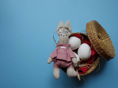 Renkli arka planda saman sepetinde üç yumurtanın şenlikli Paskalya yerleşimi