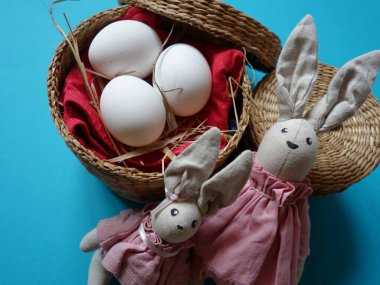 Renkli arka planda saman sepetinde üç yumurtanın şenlikli Paskalya yerleşimi