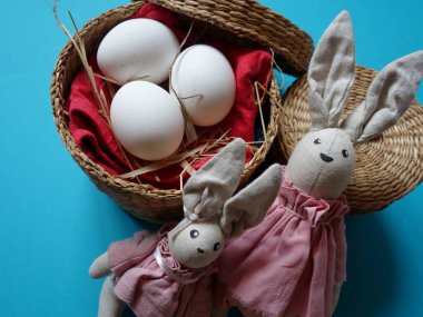 Renkli arka planda saman sepetinde üç yumurtanın şenlikli Paskalya yerleşimi