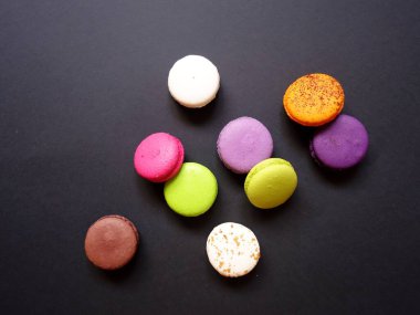 Katı renk arkaplanındaki renkli badem kurabiyelerinin düzeni