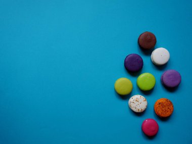 Katı renk arkaplanındaki renkli badem kurabiyelerinin düzeni