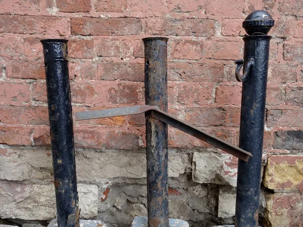 Old City Road Posts Made Metal Stand Red Brick Wall — Stock Photo, Image