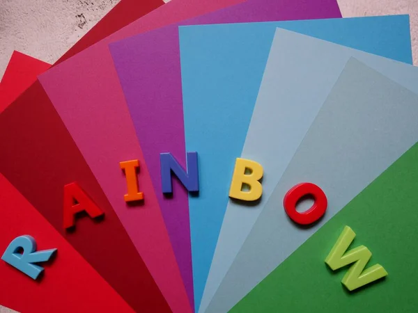 layout of colored sheets of paper on the surface in the form of a rainbow fan