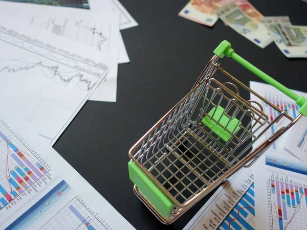 empty consumer basket against the background of financial charts and currencies