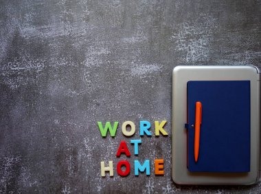 Uzak çalışma için yüzeyde bir dizüstü bilgisayar, kalem ve defter düzeni