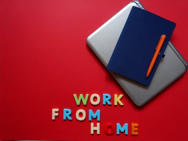 Uzak çalışma için yüzeyde bir dizüstü bilgisayar, kalem ve defter düzeni