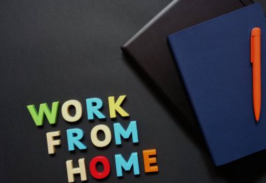Uzak çalışma için yüzeyde bir dizüstü bilgisayar, kalem ve defter düzeni