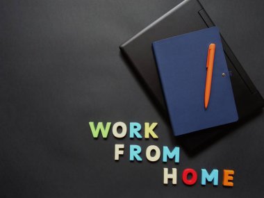 Uzak çalışma için yüzeyde bir dizüstü bilgisayar, kalem ve defter düzeni