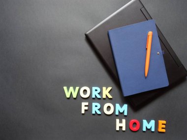 Uzak çalışma için yüzeyde bir dizüstü bilgisayar, kalem ve defter düzeni