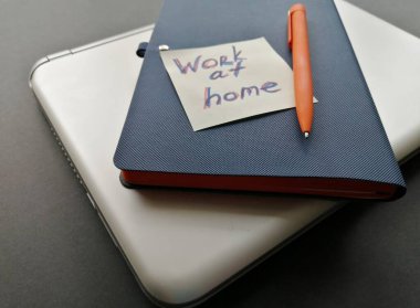 Uzak çalışma için yüzeyde bir dizüstü bilgisayar, kalem ve defter düzeni