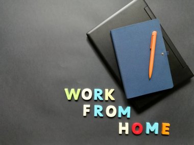 Uzak çalışma için yüzeyde bir dizüstü bilgisayar, kalem ve defter düzeni