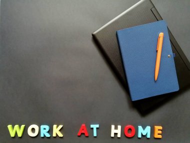 Uzak çalışma için yüzeyde bir dizüstü bilgisayar, kalem ve defter düzeni