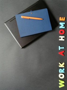 Uzak çalışma için yüzeyde bir dizüstü bilgisayar, kalem ve defter düzeni