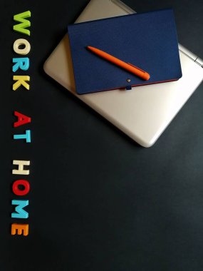 Uzak çalışma için yüzeyde bir dizüstü bilgisayar, kalem ve defter düzeni