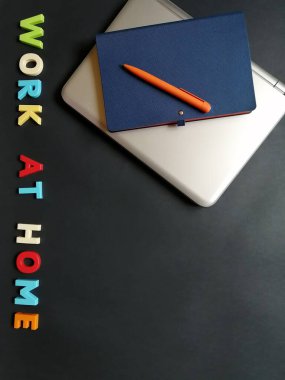 Uzak çalışma için yüzeyde bir dizüstü bilgisayar, kalem ve defter düzeni