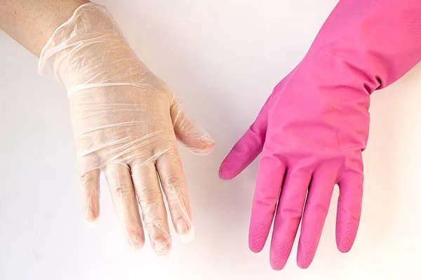 Hands in latex and rubber gloves on a white background